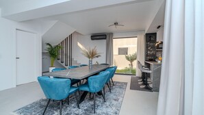 A modern dining area with a marble table, blue chairs, and a potted plant. - Gorgeous home in Privlaka (Privlaka)