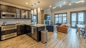 Una cocina moderna con electrodomésticos de acero inoxidable, una isla grande y una pared de acento de piedra.