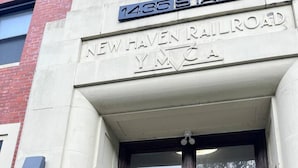 Ingången till New Haven Railroad och Y.M.C.A. består av en dubbeldörr i trä och en liten trappsteg som leder upp till dörren.