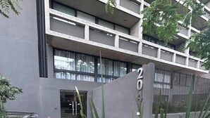 Ein modernes Gebäude mit einer geometrischen Fassade, einem verschlossenen Eingang und einem gemusterten Weg.