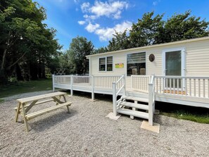 A mobile home with a deck and a picnic table.