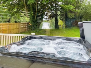 A hot tub with a wooden deck and a view of a pond and trees. - Shirley's Haven - UK46631 (Driffield)