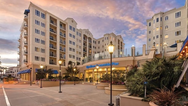 Un hôtel à plusieurs étages doté d’une cour intérieure, de sièges en plein air et d’un restaurant appelé « Wynn OceanSide Pier ».
