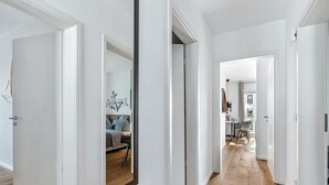 Moderni eteinen, jossa on puulattia ja valkoiset seinät.
