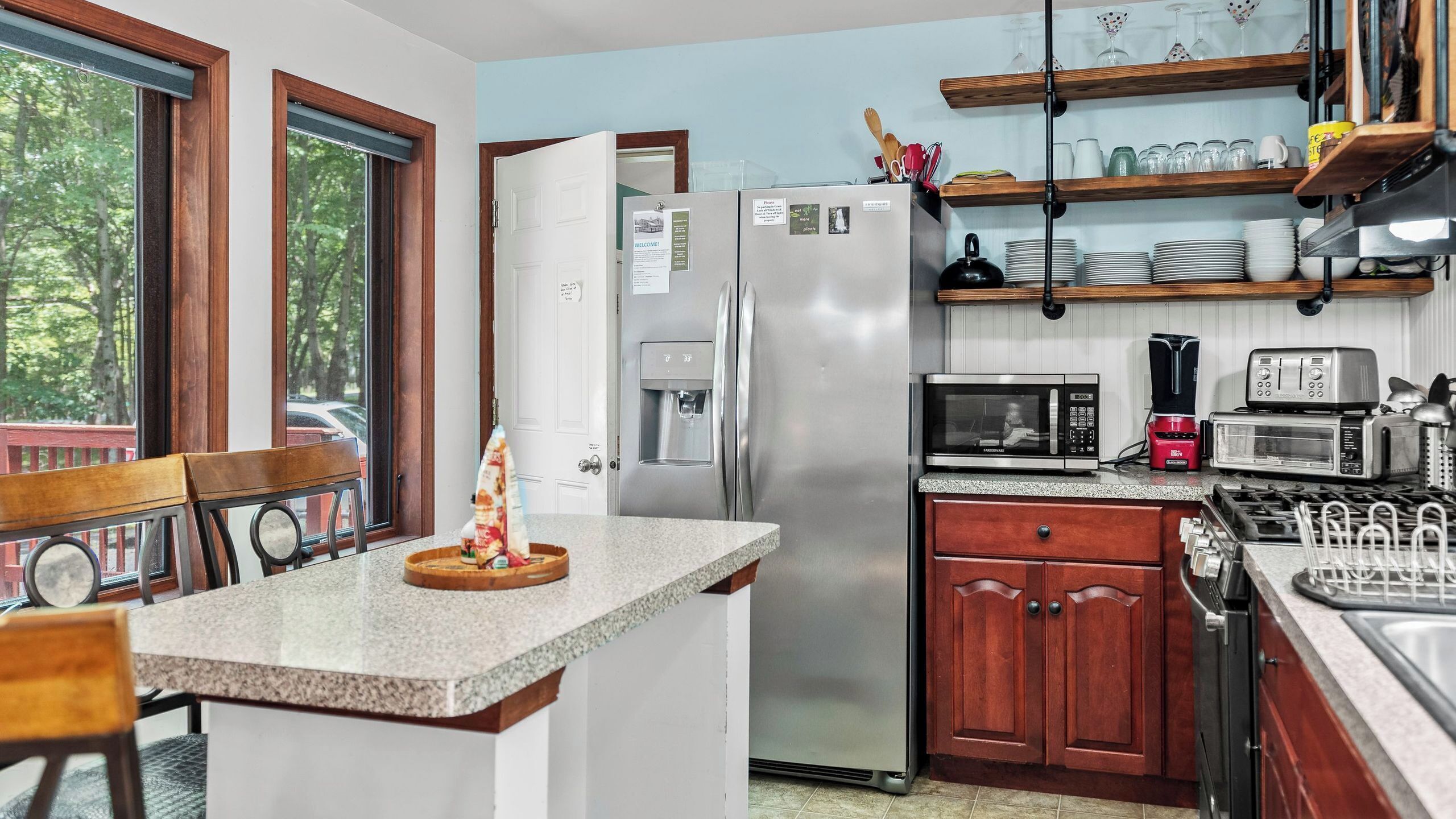 A kitchen with a refrigerator, microwave, toaster, and coffee maker.