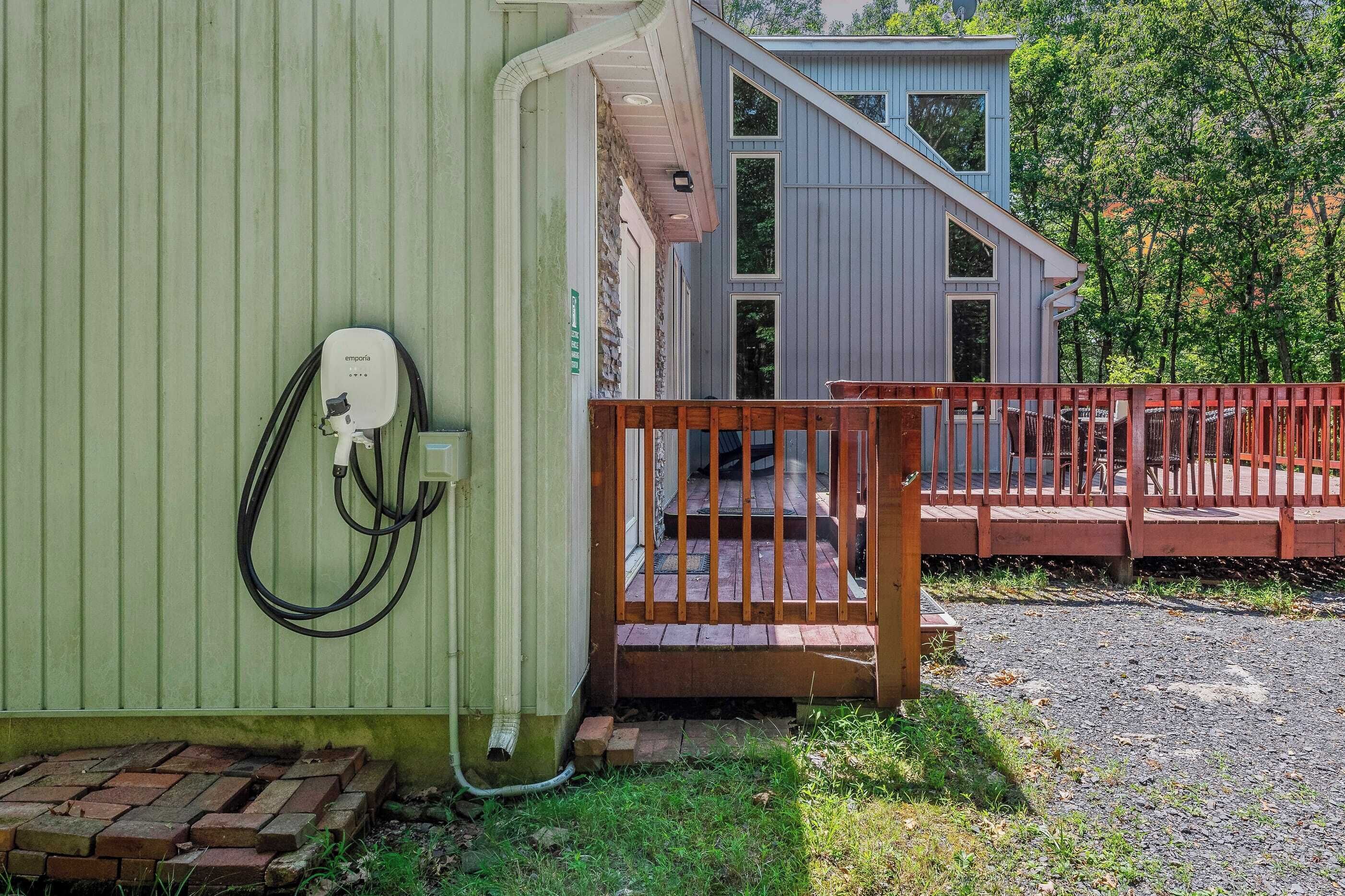 A building with a green exterior wall, a wooden deck, and a visible electrical box.