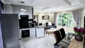 Una cocina moderna con comedor, ventanas amplias y un televisor de pantalla plana.
