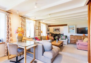 Relax in a warm and inviting space with a comfortable sofa set, glass-top dining table, and cozy seating area.
