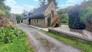 A stone building with a steeply pitched roof, a wooden staircase, and a gravel driveway. - Lovely home in Saint-Thurien with WiFi (Saint-Thurien)
