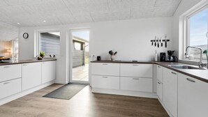 A modern kitchen with white cabinets, a wooden countertop, and a view to the outside. - Awesome home in Tarm with WiFi (Tarm)