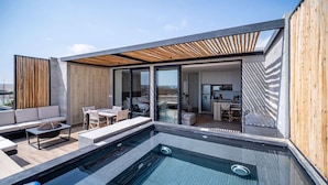 A modern rooftop terrace with a swimming pool, outdoor seating, and a kitchen area.
