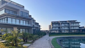Un conjunt d'edificis moderns amb diverses plantes, un camí de grava i una font.