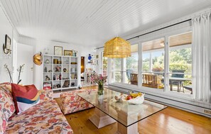 A spacious living room with a glass coffee table, floral sofa, and a large window with a view of the outdoors. - Awesome home in Højby with WiFi (Højby)