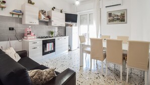 A modern kitchen with a dining area, featuring a sofa, dining table, and chairs. - Cozy apartment in Mondragone with WiFi (Mondragone)