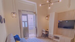 A modern living room with a sofa, a TV, and a patterned floor. - Cozy 1-bedroom suite in amazing Puebla with WiFi and living room with extra bed (Heroica Puebla de Zaragoza)