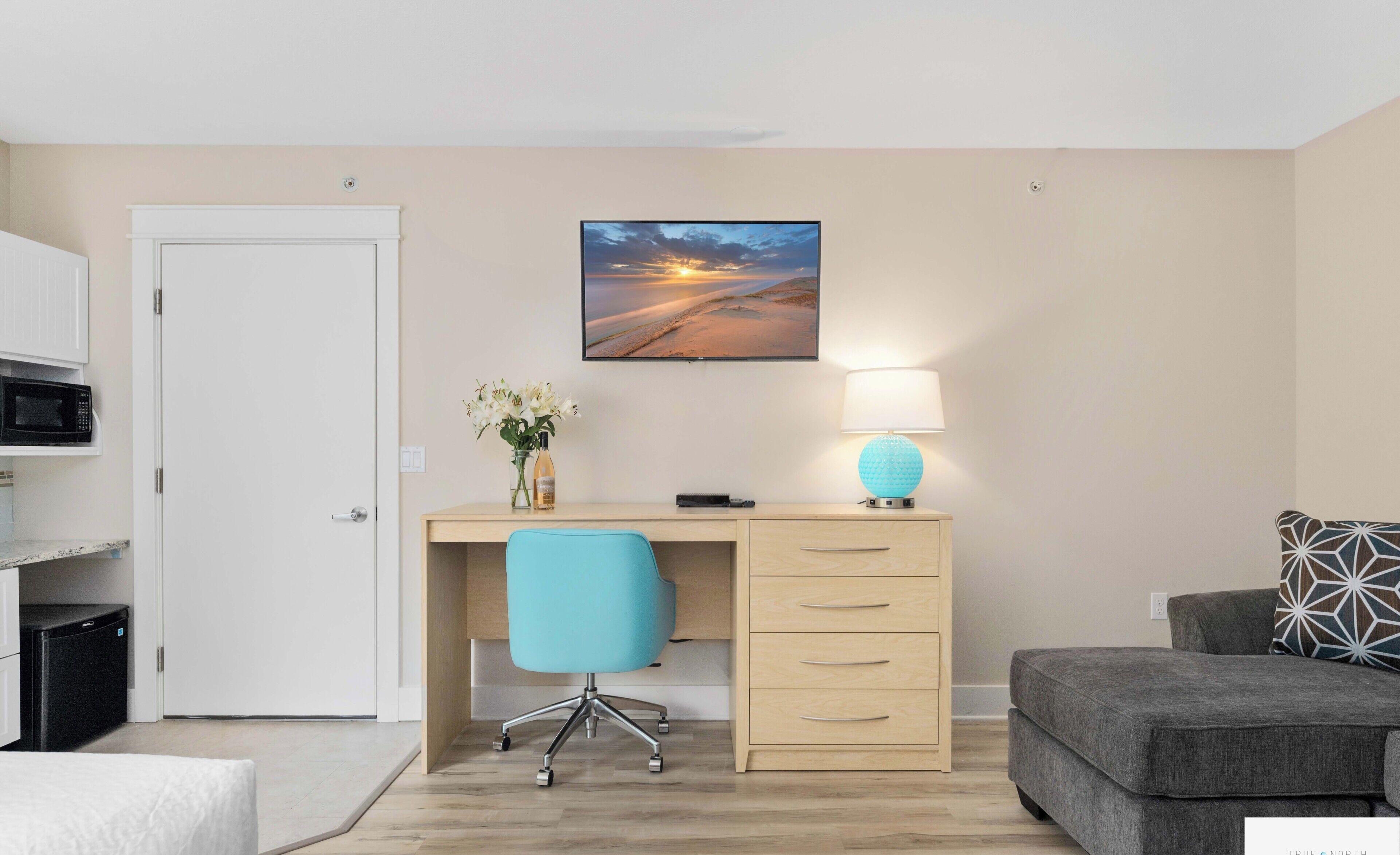 A modern room with a desk, chair, and a bed.
