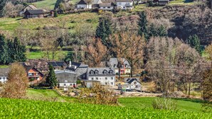 A rural village with houses on a hillside, a field in the foreground, and a clear sky. - Cozy apartment in Irrhausen with sauna (Irrhausen)