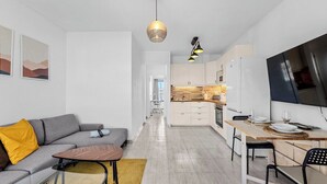 A modern apartment with a living area, kitchen, and dining space.