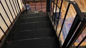 A wooden interior with a staircase leading to a kitchen area.