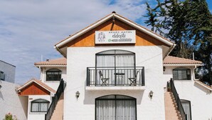 A two-story building with a sign reading "APART HOTEL eldento." It features a balcony with outdoor furniture, a staircase, and a gated entrance. - ELDEPTO LA SERENA (Coquimbo)