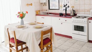 A kitchen with a dining table, chairs, a stove, and a window. - ELDEPTO LA SERENA (Coquimbo)