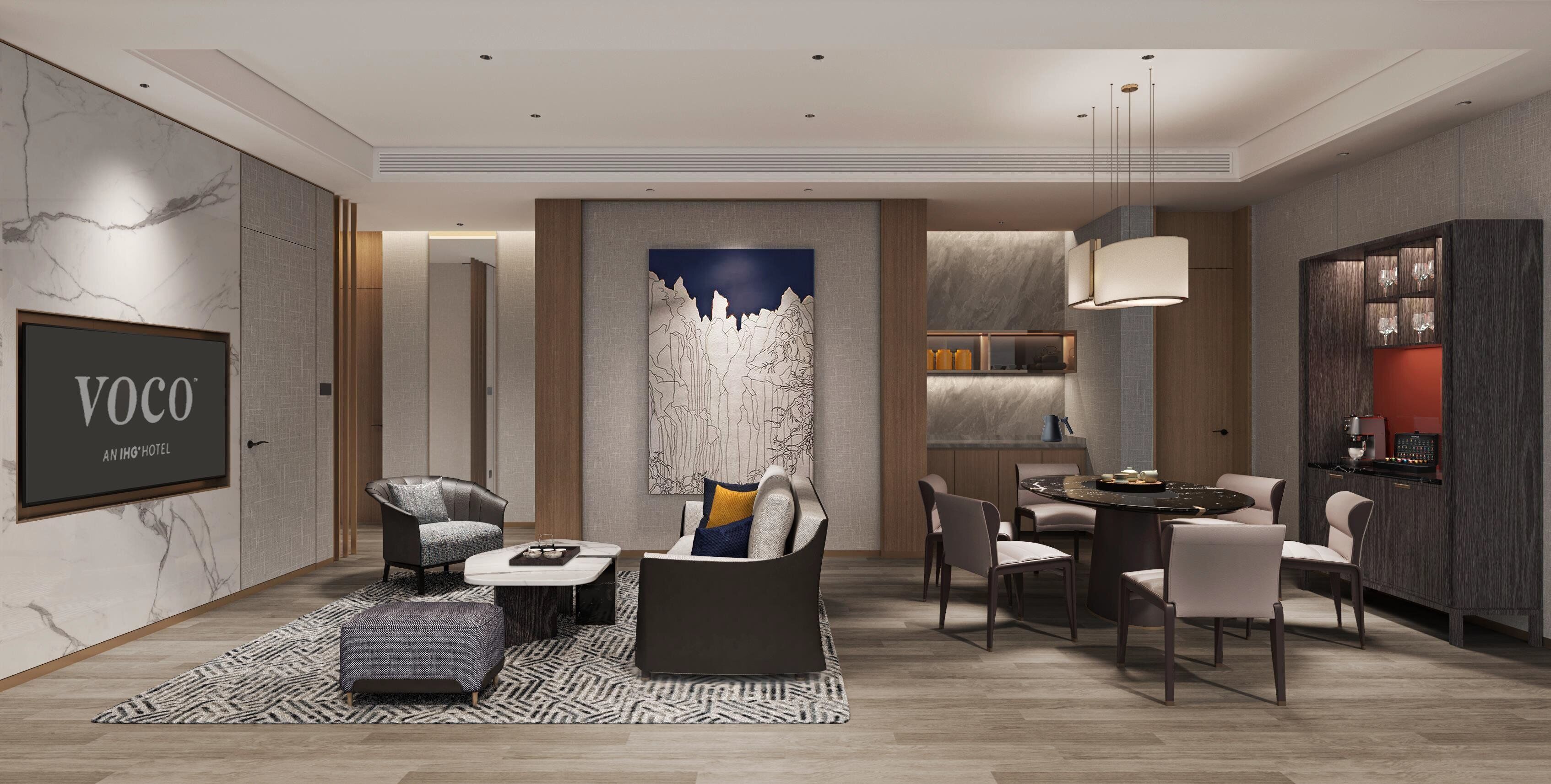 Eine moderne Hotellobby mit einer Couch, Sesseln, einem Essbereich und einer Küche.