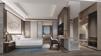 Una habitación de hotel moderna con cama, escritorio, silla y televisión.