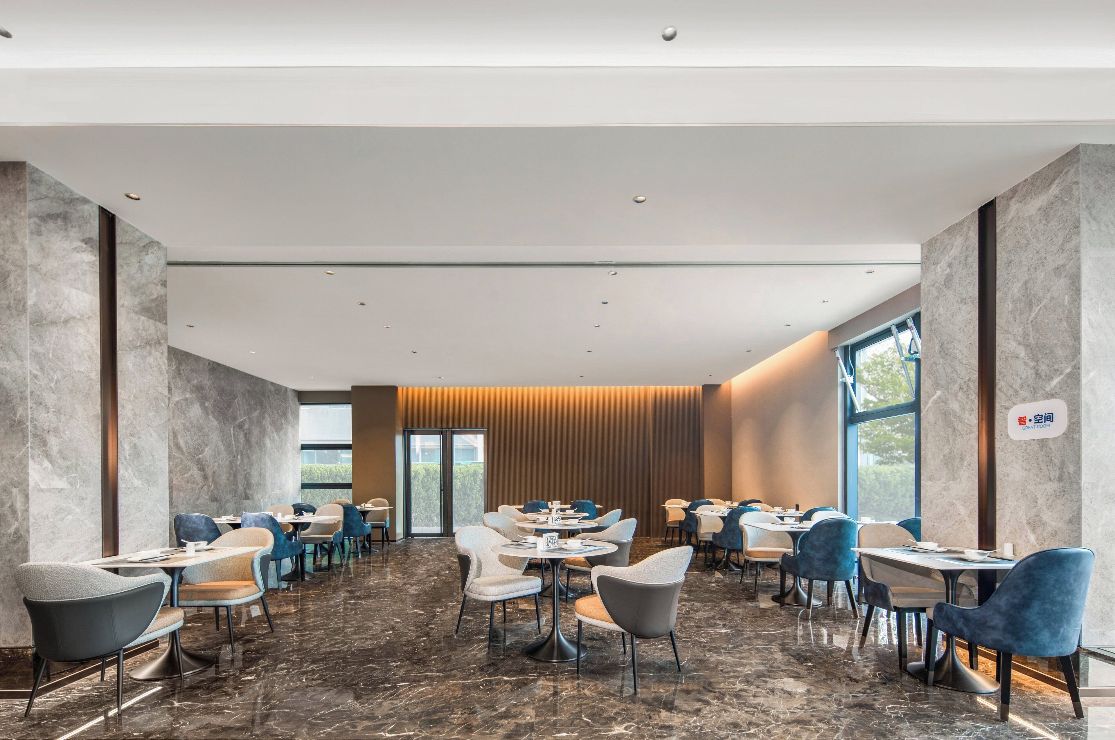 A spacious conference room with marble flooring, modern tables, and chairs arranged for meetings.