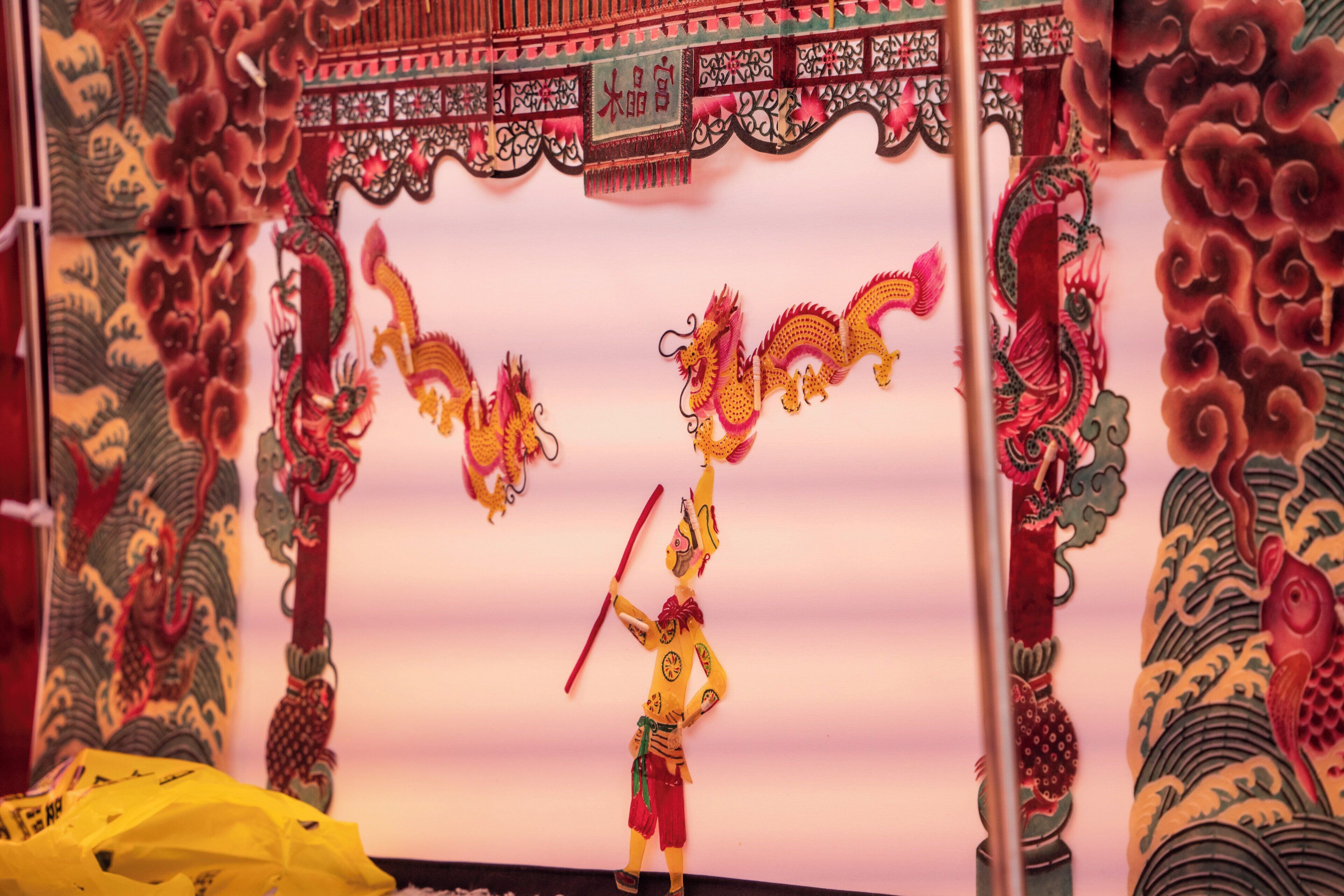 Una presentación de la danza del dragón china tradicional, con diseños intrincados y un artista disfrazado.