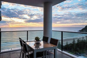 Enjoy the ocean view from this balcony with a table and chairs, perfect for taking in the sights.