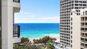 A high-rise hotel with a view of the ocean and beach.