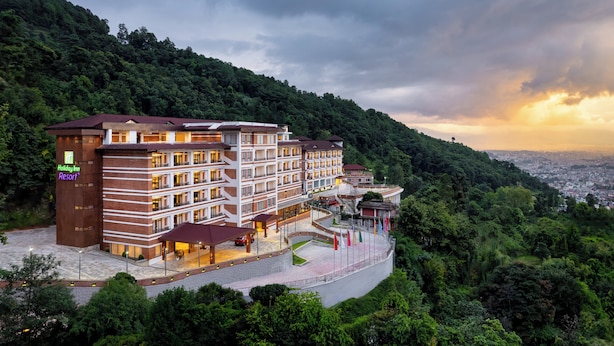 A multi-story Holiday Inn Resort building with a brick facade, multiple balconies, and a landscaped courtyard. - Holiday Inn Resort Kathmandu Budhanilkantha by IHG (Burhanilkantha)