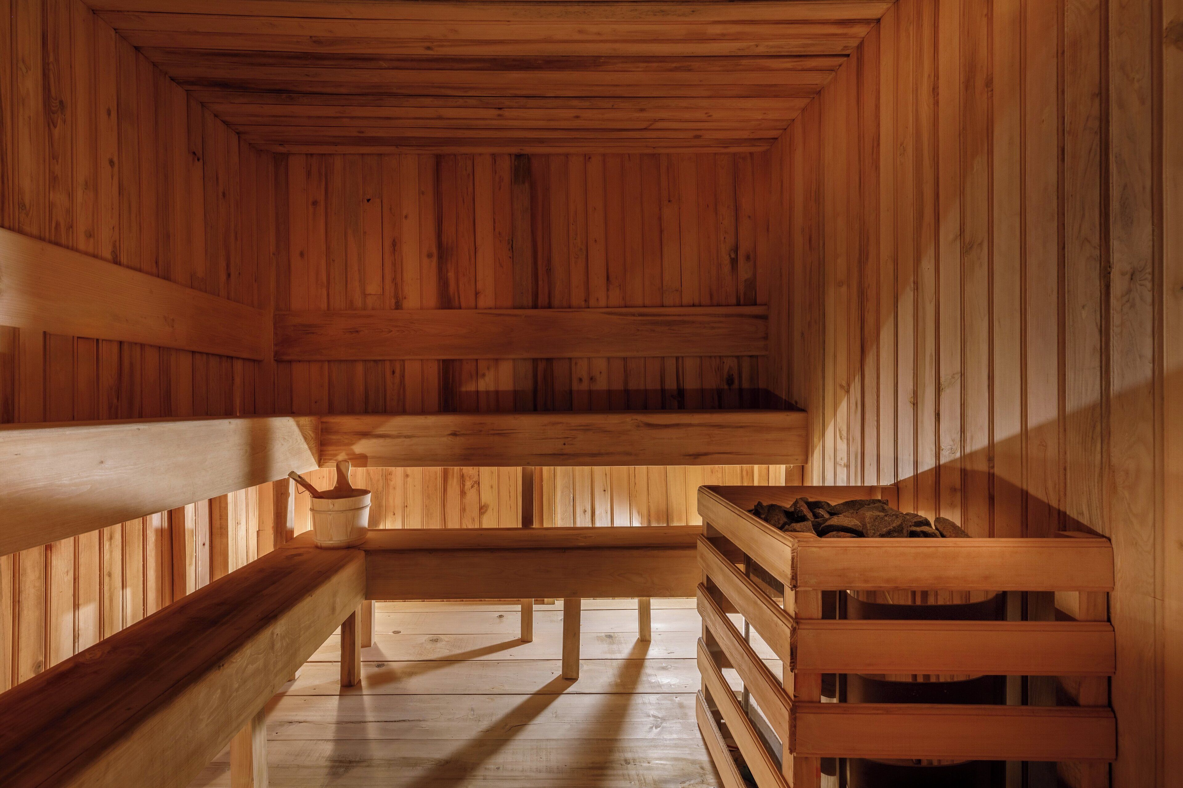 Una sauna de madera con bancos y una mesa.