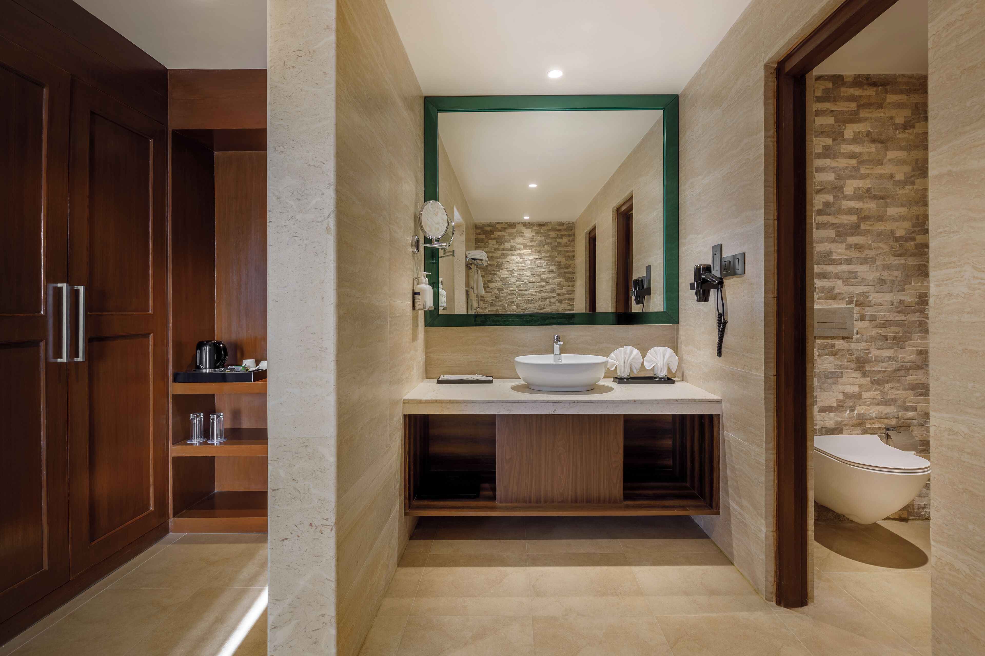 A modern bathroom with a large mirror, a sink, and a toilet.