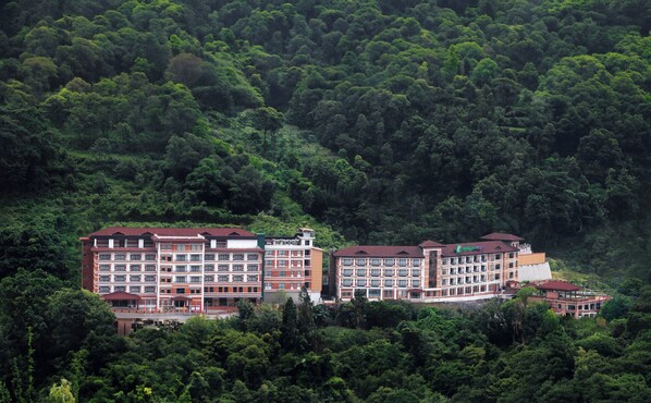 A multi-story hotel with a red roof, surrounded by dense forest. - Holiday Inn Resort Kathmandu Budhanilkantha by IHG (Burhanilkantha)
