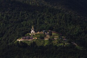 A large white stupa surrounded by buildings on a hillside. - Holiday Inn Resort Kathmandu Budhanilkantha by IHG (Burhanilkantha)