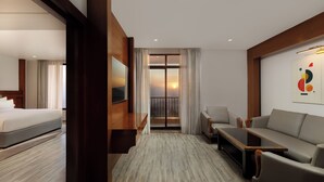 A hotel room with a bed, a sofa, a coffee table, a TV, and a balcony with a sunset view. - Holiday Inn Resort Kathmandu Budhanilkantha by IHG (Burhanilkantha)