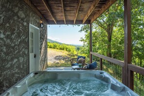 Ein Whirlpool mit einer Holterrasse und Blick auf einen Weinberg.