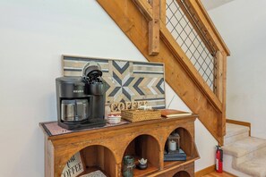 A coffee station with a Keurig machine, a coffee cup, and a basket with coffee beans. - Cozy Cabin in town with a View! Hot Tub+Grill+WiFi (Burnsville)