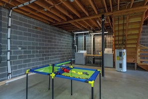 A room with a foosball table, a refrigerator, and a workbench. - Cozy Cabin in town with a View! Hot Tub+Grill+WiFi (Burnsville)