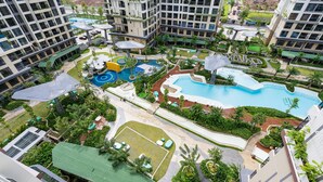 A modern residential complex with multiple high-rise buildings, a central swimming pool, and landscaped gardens. - Yumy Homestay Grand Park City (Ho Chi Minh City)