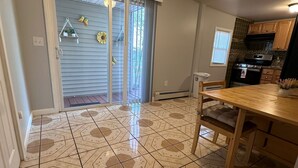 A kitchen with a stove, oven, and a dining area with a table and chairs. - Charming 2-bedroom house with WiFi, AC in pleasant Meriden (Meriden)