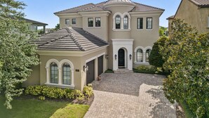 A two-story house with a brick driveway, a front porch, and a landscaped yard. - Theater | Games Area | Pool Area with BBQ (Kissimmee)