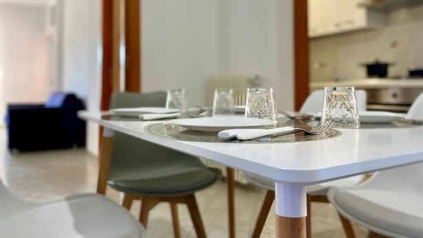 A dining table set with plates, glasses, and cutlery. - Three-Bedroom Apartment - Rosanna's House (Monopoli)