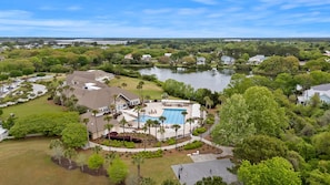 A residential area with a swimming pool, houses, and a lake. - Summerwind Cottage on Seabrook, Club Access, Golf Cart, Games! (Seabrook Island)