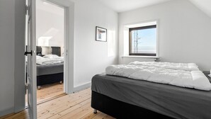 A bedroom with a bed, a window, and a door leading to another room. - 3 bedroom pet friendly home in Ribe (Ribe)