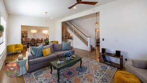 A spacious living room with a sofa, coffee table, and a staircase leading to another level.