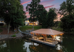 A lakeside gazebo with a covered seating area, a dock, and a house in the background. - Waddell Waters w/Optional Boat Rental (Mooresville)