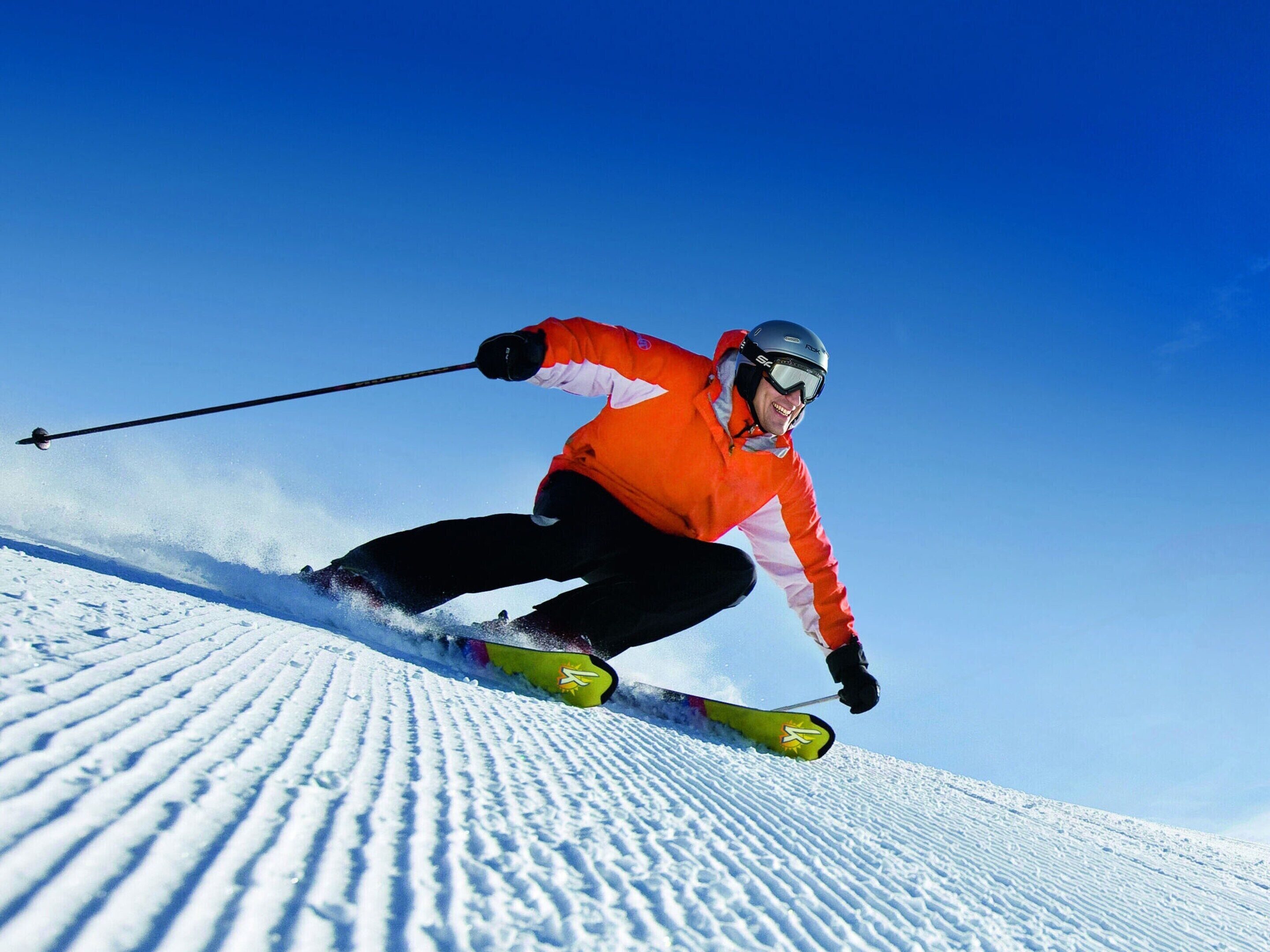Eine Person fährt auf Skiern einen schneebedeckten Hang hinab.