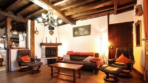 Ein gemütliches Wohnzimmer mit Kamin, Ledersofas und einem Holztisch.